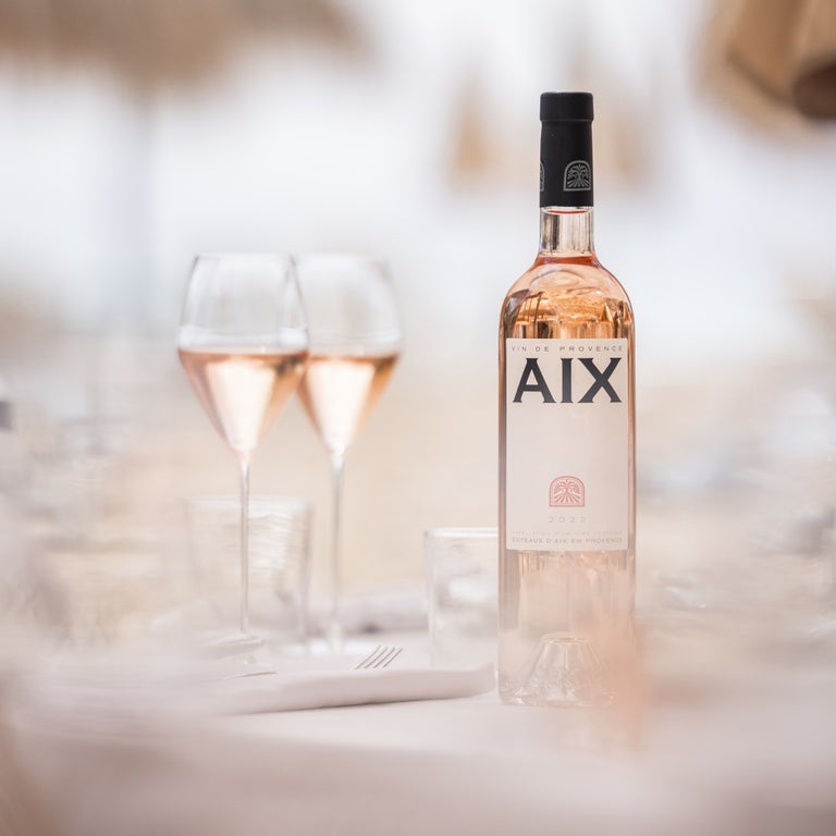 Twee glazen gevuld met Aix rose en een volle fles rose ernaast