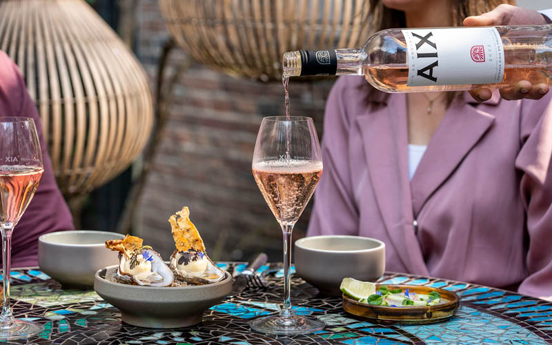 Glas Aix rose wordt ingeschonken op een terras