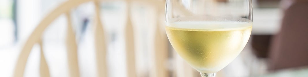 Lichte achtergrond met beslagen glas witte wijn