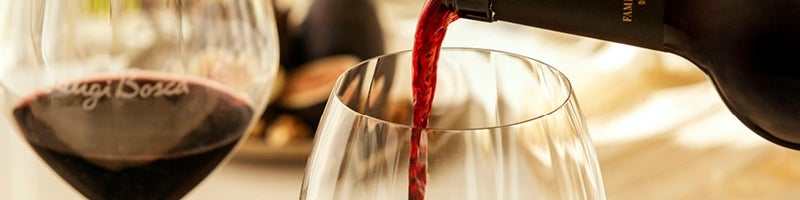 Glas luigi bosca wordt gevuld met rode wijn