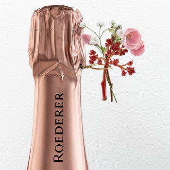 Champagnefles Roederer met bloemen om de hals