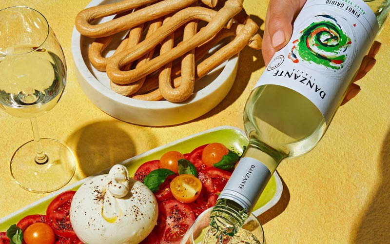 Tafel met een burrata salade en een fles witte wijn
