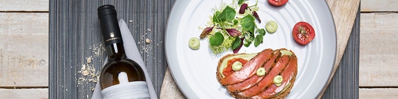 Fles wijn naast een bord met eten