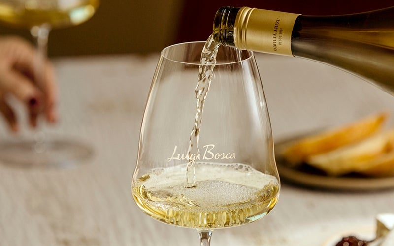 Glas witte wijn wordt ingeschonken